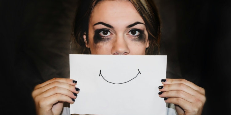 A person holding white printer paper. Overcoming Burnout: Rediscovering Joy in Your Work - Mania Work