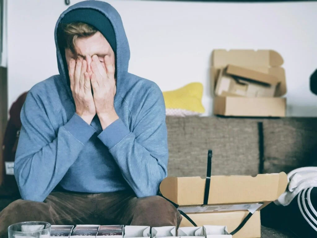 Overcoming Burnout: Rediscovering Joy in Your Work 2 | Mania Africa | maniainc.com A man covering his face with both hands while sitting on bench. Overcoming Burnout: Rediscovering Joy in Your Work - Mania Business