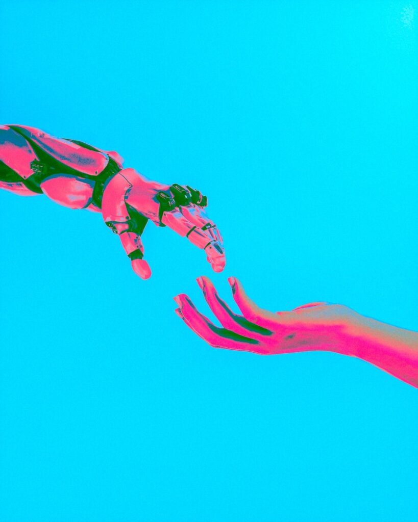Preventing AI Chat Data Theft: Enhancing Security Against Malicious Chrome Extensions & How to Protect Your Privacy 10 | Mania Africa | maniainc.com A robot hand reaching out to a human hand symbolizing the need for human-AI collaboration for increased AI chat data security.