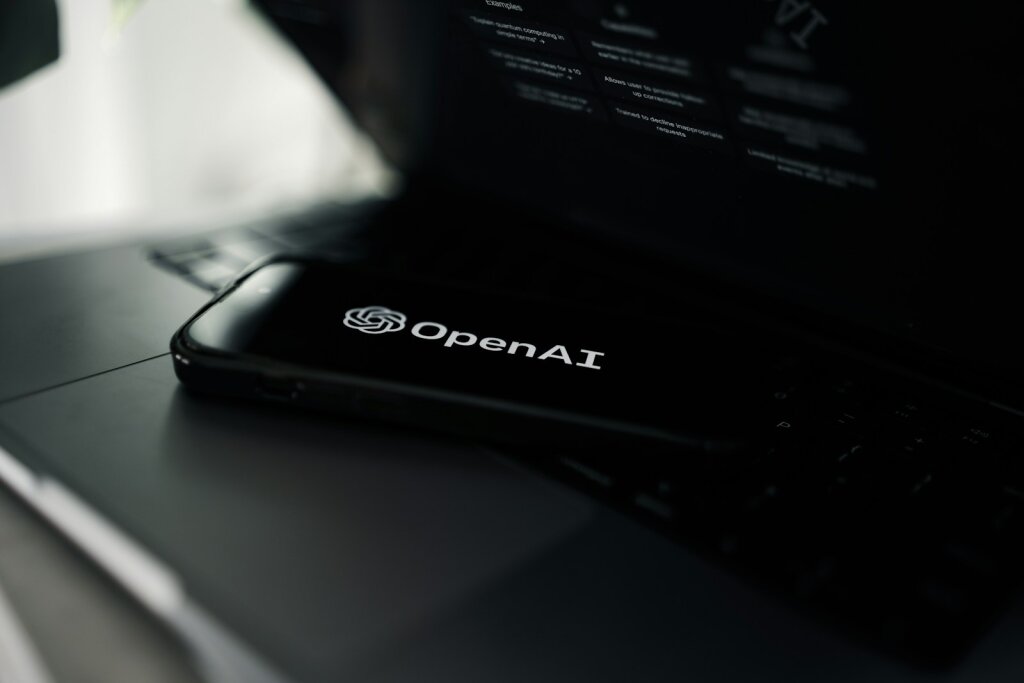 A close up of a smartphone showing the OpenAI logo on a desk - OpenAI's Rationale: Why Push to GPT-5? - Mania Technology