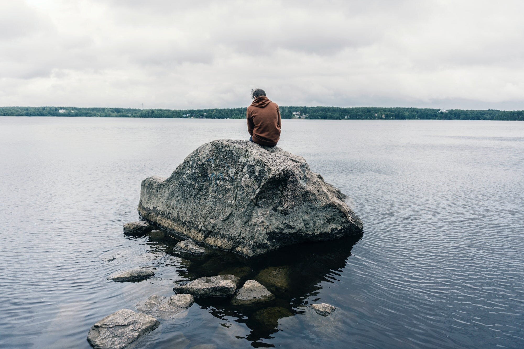 How to Move On After a Breakup When You Still Love That Person: A Comprehensive Guide to Healing and Letting Go 2 | Mania Africa | maniainc.com A photo of a man sitting on a rock on the coast of Baltic sea in Baltic gulf.