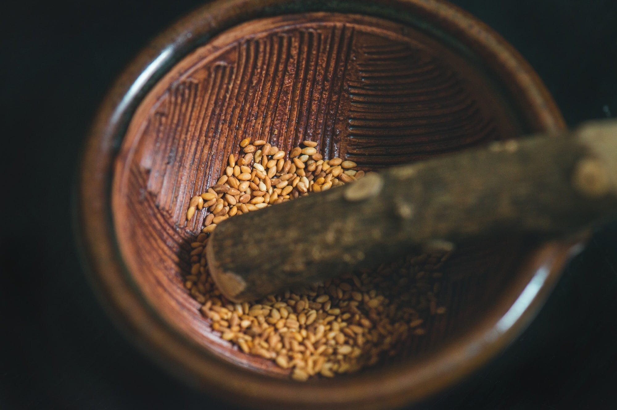 Vegan Nutrition 101: How to Get All the Nutrients You Need on a Plant-Based Diet 3 | Mania Africa | maniainc.com Roasted sesame seeds in a wooden grinding bowl