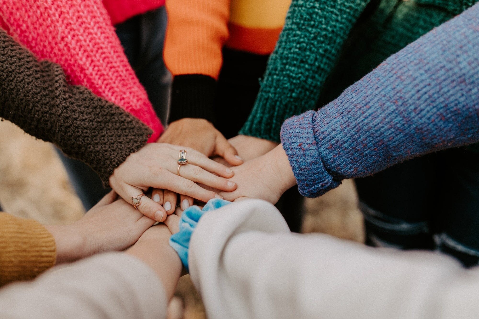 Exploring the Power of Thought: From Brain-Machine Interfaces to Genetics and Aging 7 | Mania Africa | maniainc.com An image of the arms of several women put together in a show of solidarity, community, and support for each other