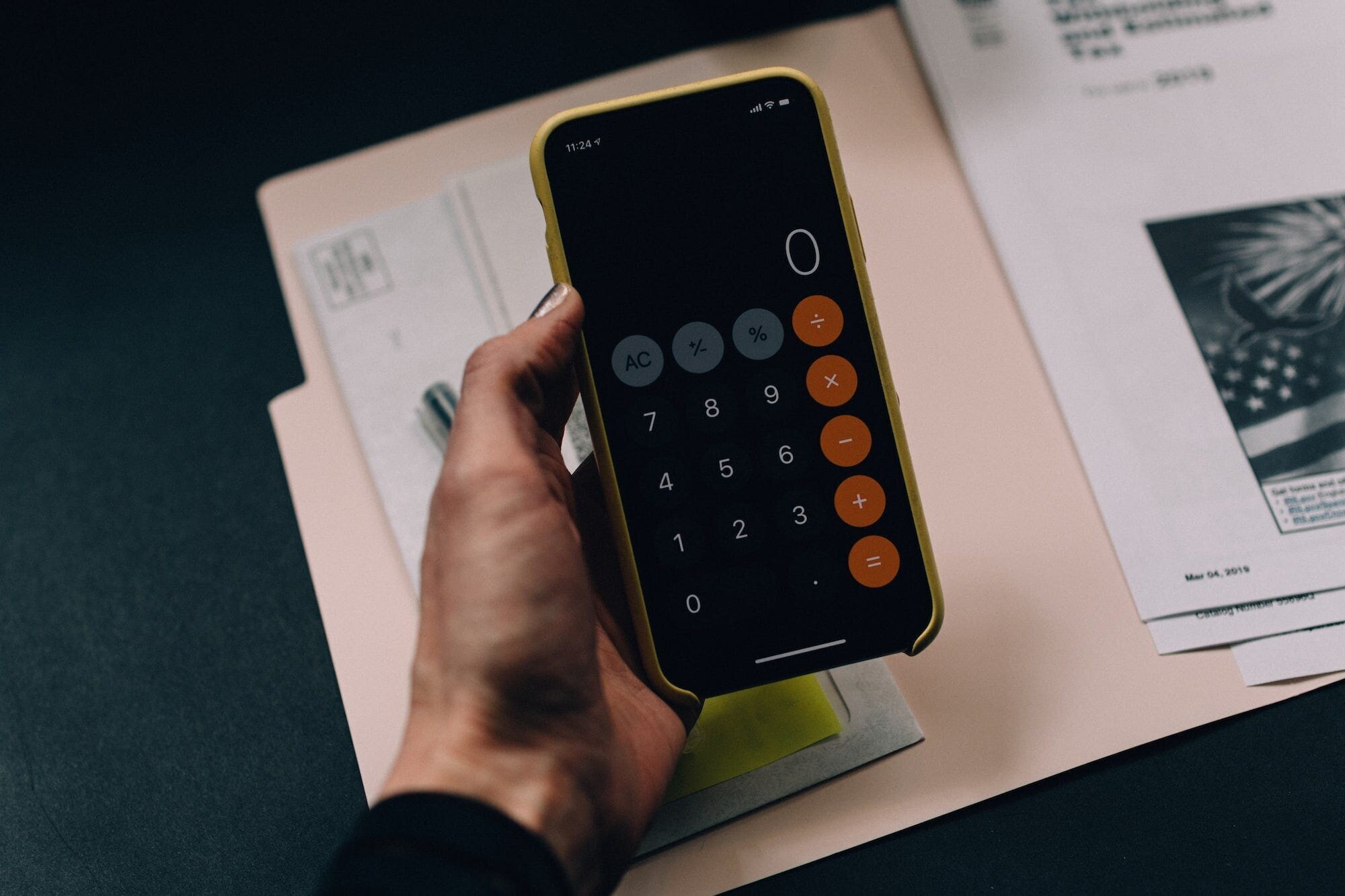 Personal Finance: Tips and Tricks for Managing Your Money 2 | Mania Africa | maniainc.com A person with their phone in their hand with the calculator app open