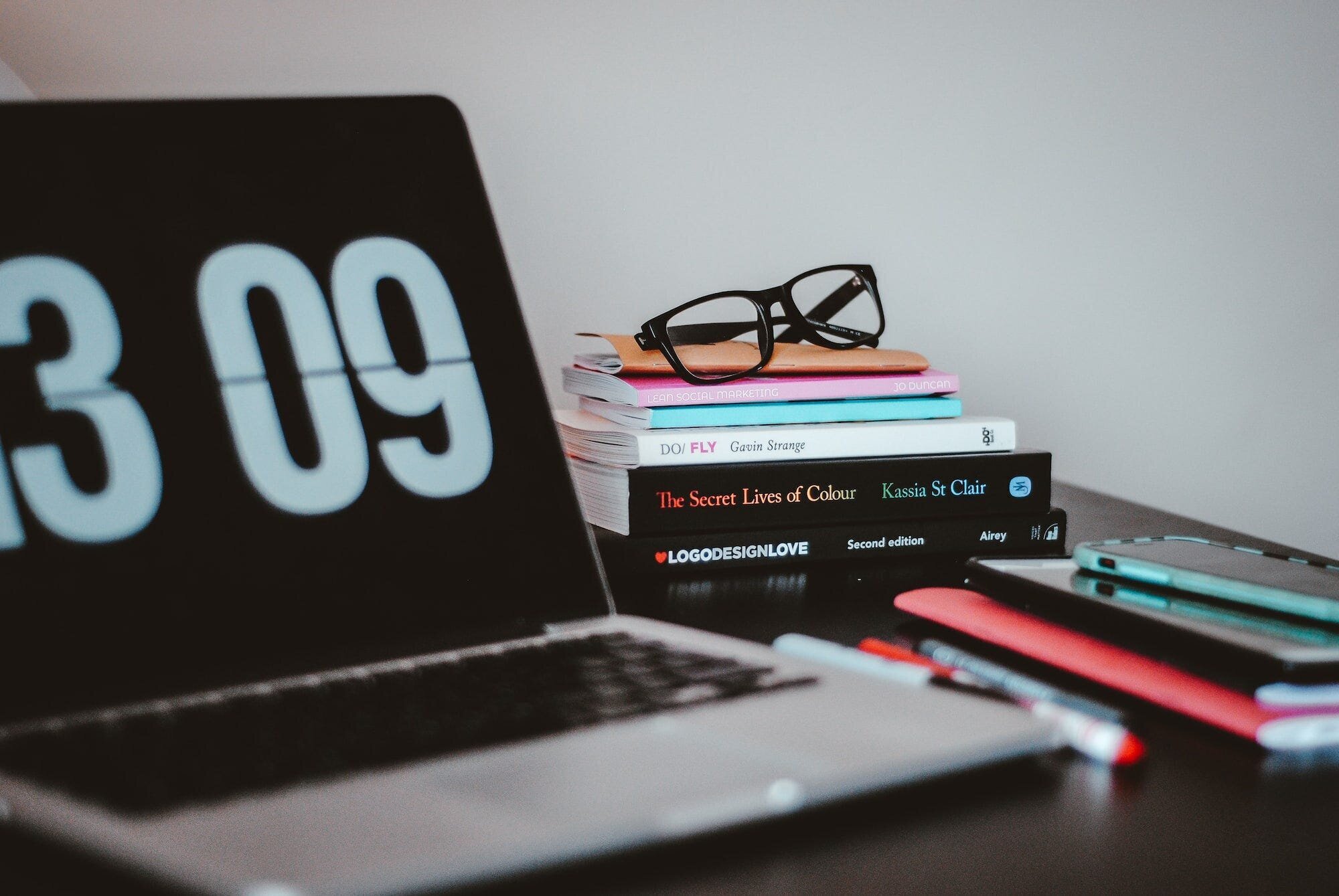 The Keys to Success on Fiverr: A Comprehensive Guide for Freelancers and Buyers 6 | Mania Africa | maniainc.com A computer showing a timer on a desk alongside books and a smartphone