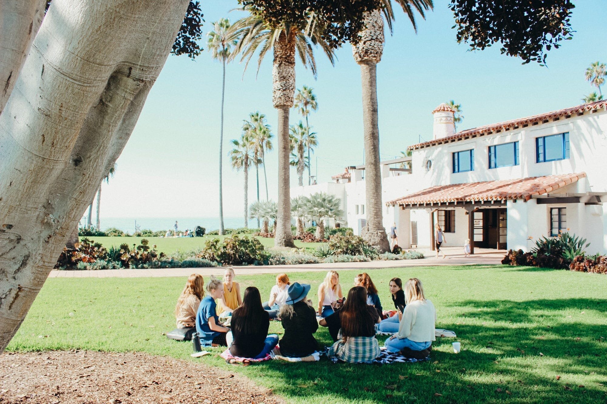 The Impact of Social Media on Mental Health: Navigating the Risks and Benefits 2 | Mania Africa | maniainc.com A group of people seated together in a circle under a tree