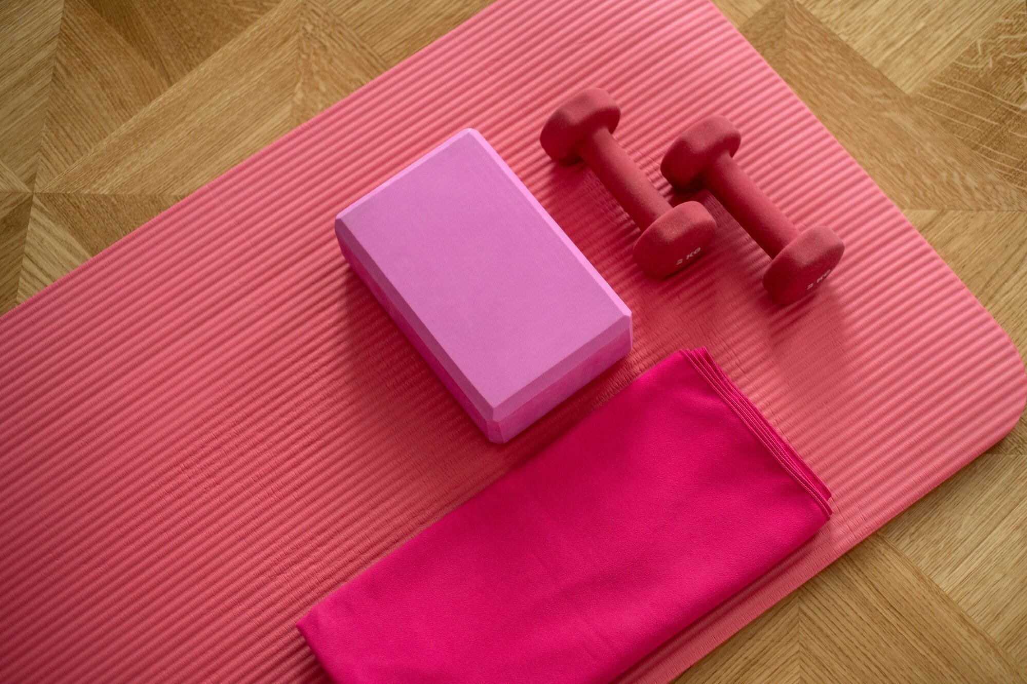 The Ultimate Guide to Strength Training with Free Weights for Women 2 | Mania Africa | maniainc.com A pink exercise mat with weights on top of it