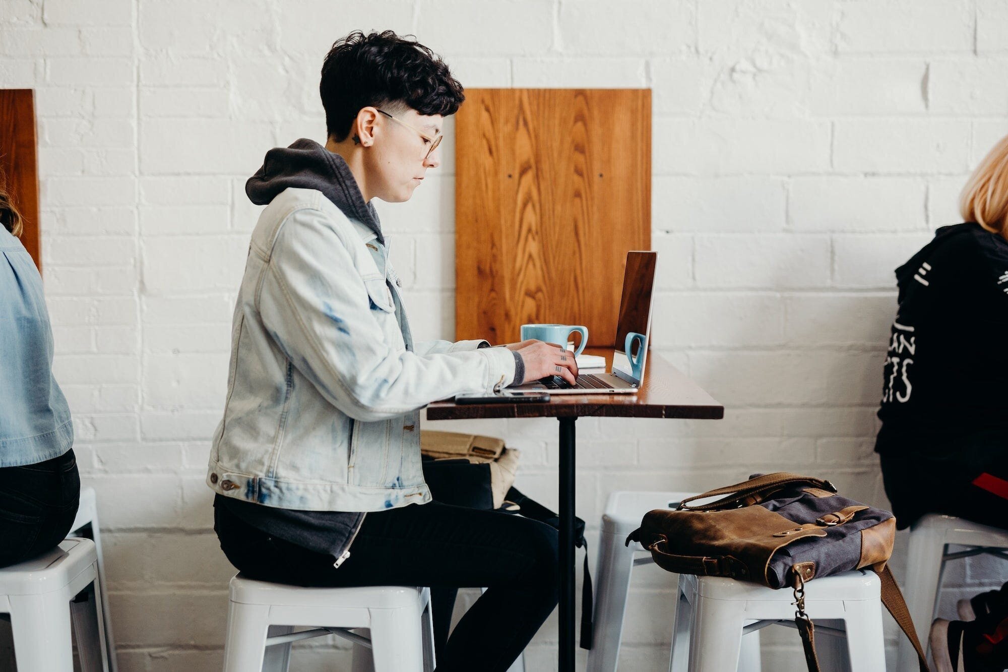 The Keys to Success on Fiverr: A Comprehensive Guide for Freelancers and Buyers 7 | Mania Africa | maniainc.com A Fiverr freelancer working in a cafe while having a cup of coffee