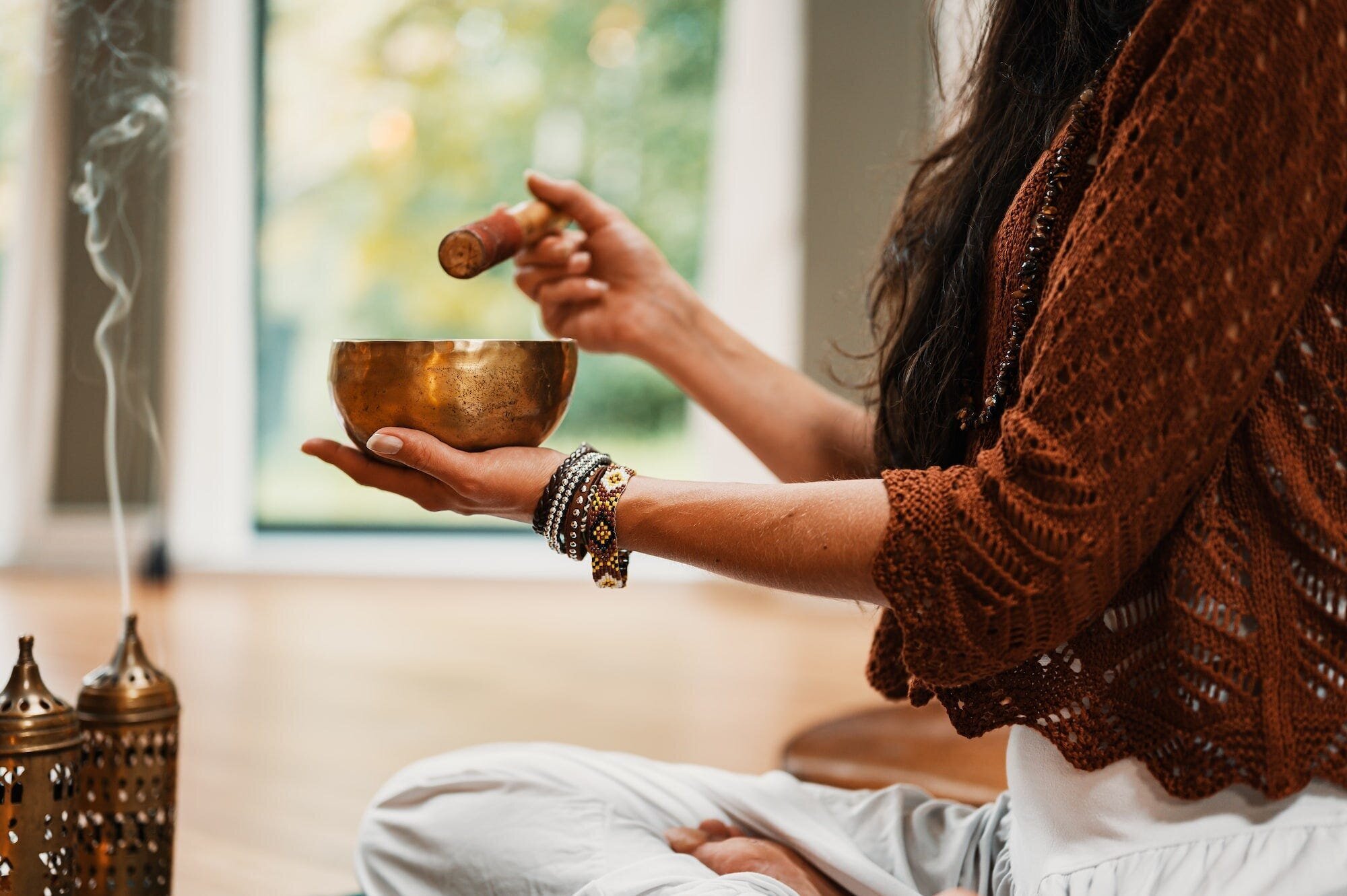 The Ultimate Guide to Meditation for Stress and Anxiety Relief 2 | Mania Africa | maniainc.com A woman meditating using a singing bowl