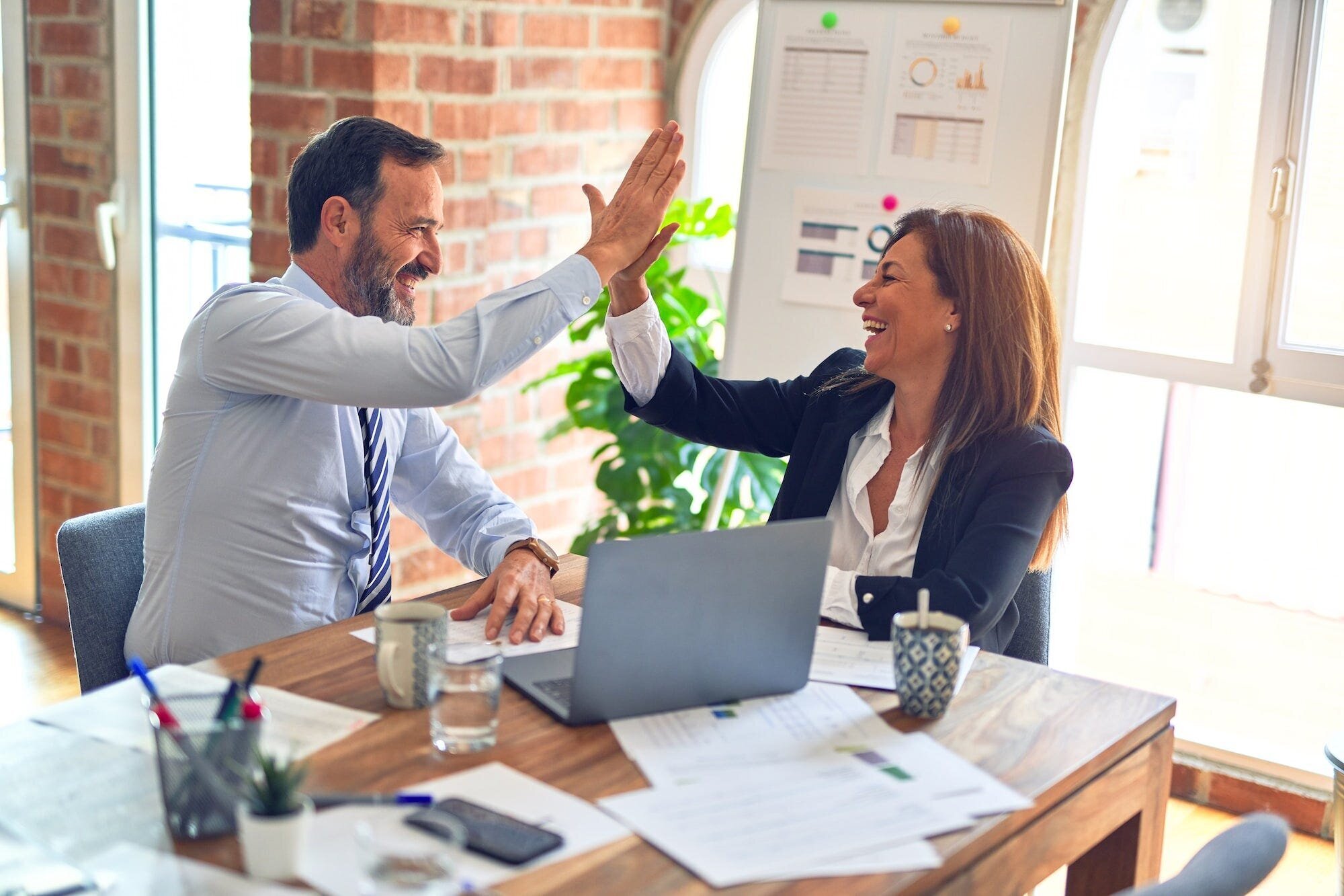 Soft Life: What it is and Why You Don't Need It 7 | Mania Africa | maniainc.com A man and woman working together and gleefuly high five each other