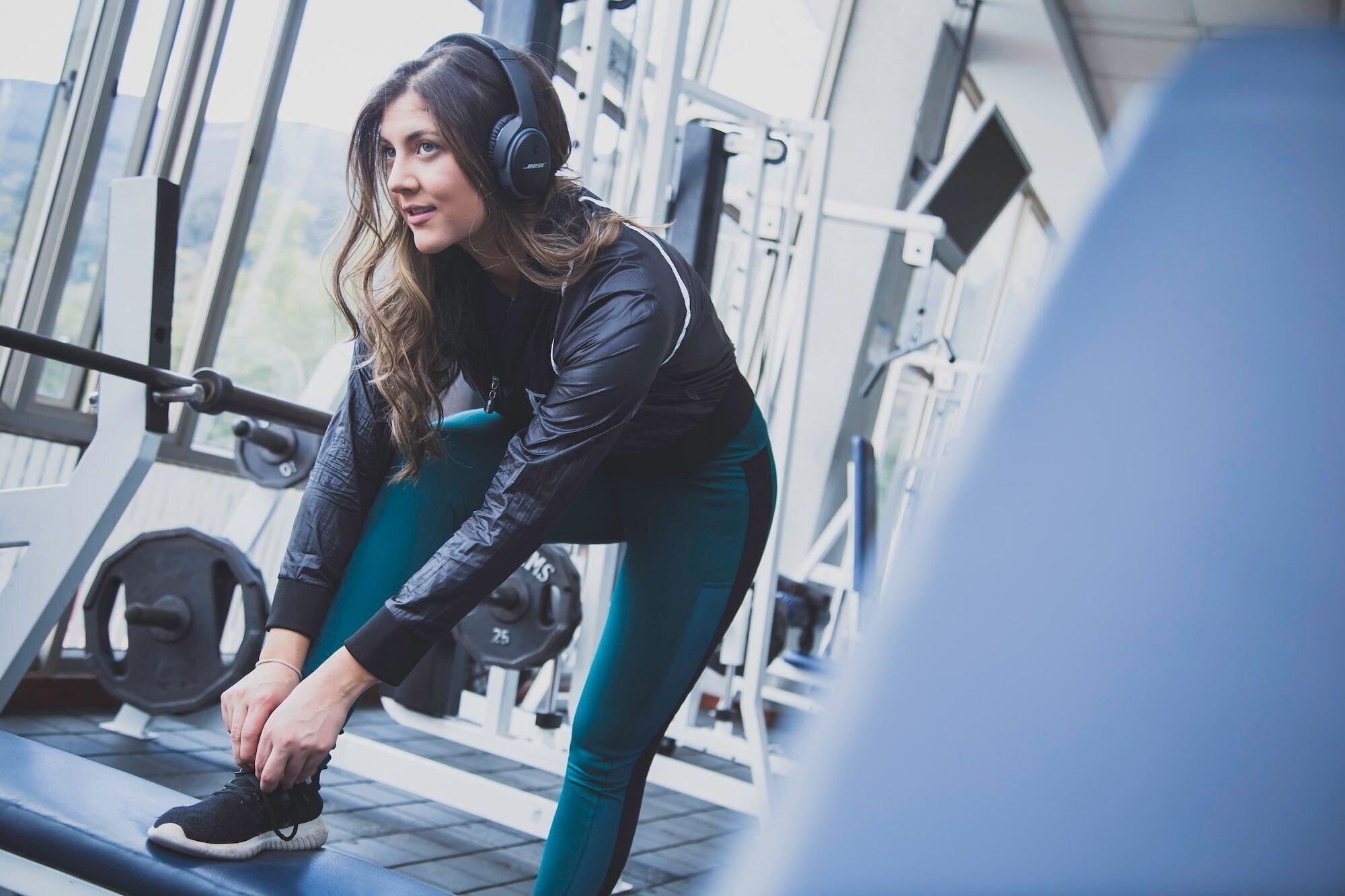 Unlock Your Gym Motivation: 7 Tips to Stay Happy and Energized During Workouts 3 | Mania Africa | maniainc.com An image of a woman working out while listening to music headphones