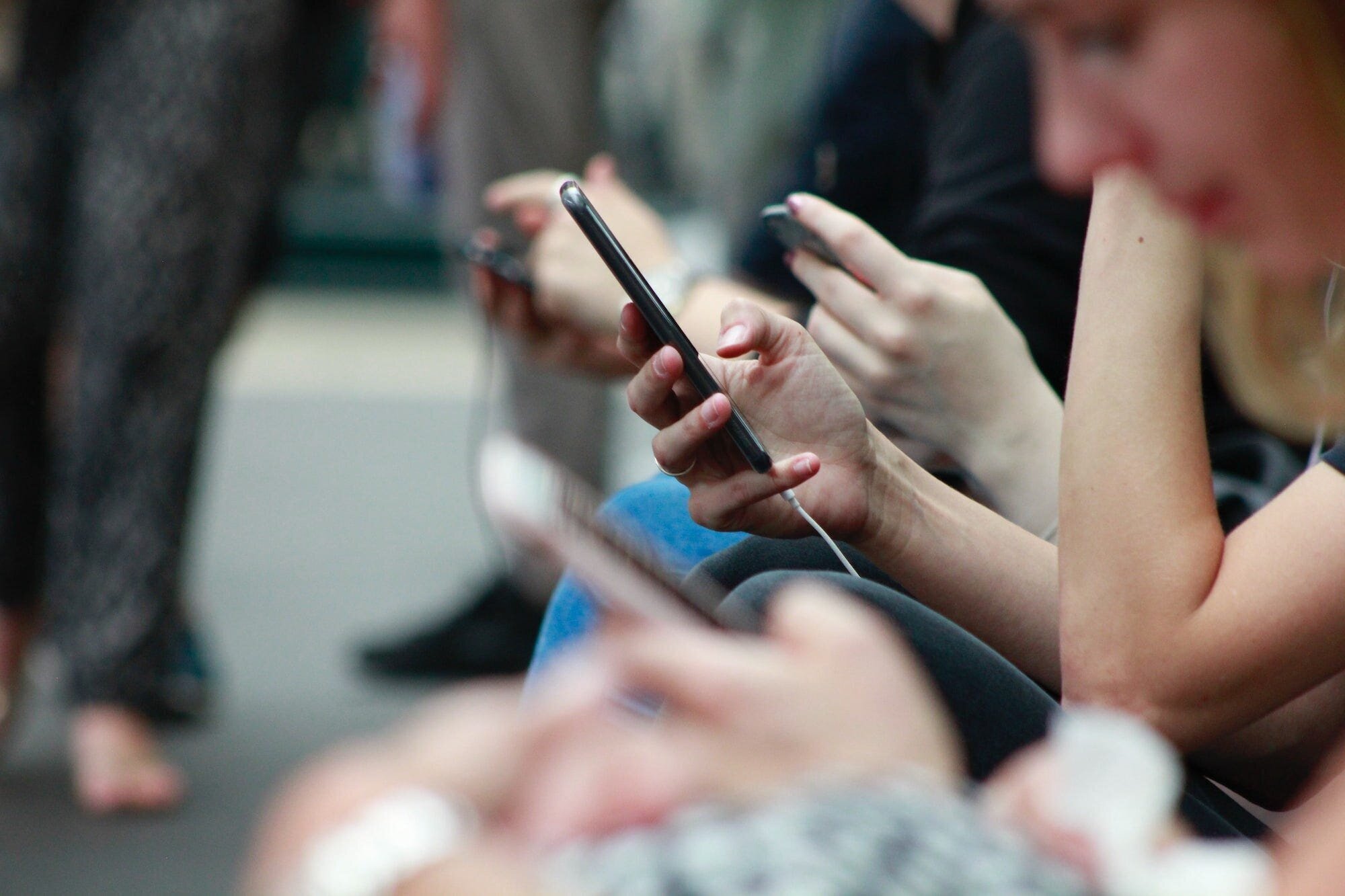 The Impact of Social Media on Mental Health: Navigating the Risks and Benefits 3 | Mania Africa | maniainc.com A group of people each on their phones scrolling