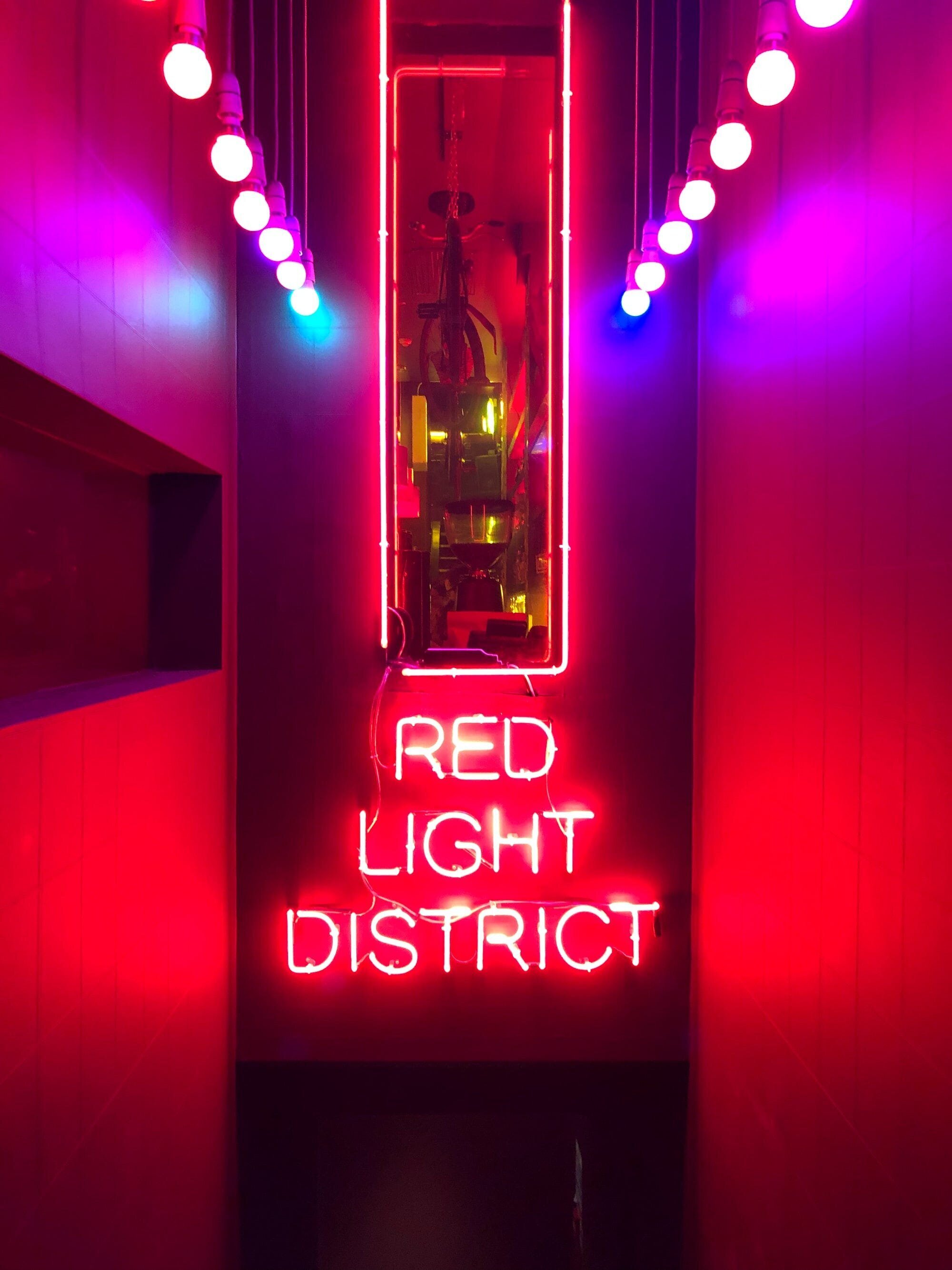 Soft Life: What it is and Why You Don't Need It 3 | Mania Africa | maniainc.com A bar in Glasgow with a neon sign reading Red Light District