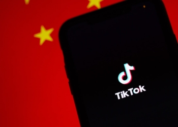 A TikTok app on a phone infront of the Chinese flag