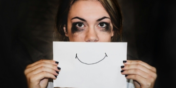 A person holding white printer paper. Overcoming Burnout: Rediscovering Joy in Your Work - Mania Work