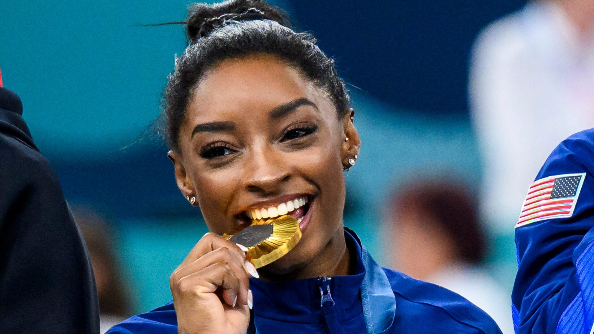 Simone Biles: How She Became the Most Decorated U.S. Gymnast of All Time 10 | Mania Africa | maniainc.com Simone biting her Olympics Gold medal | The Unstoppable Rise of Simone Biles: What is Simone Biles famous for? | Mania Sports