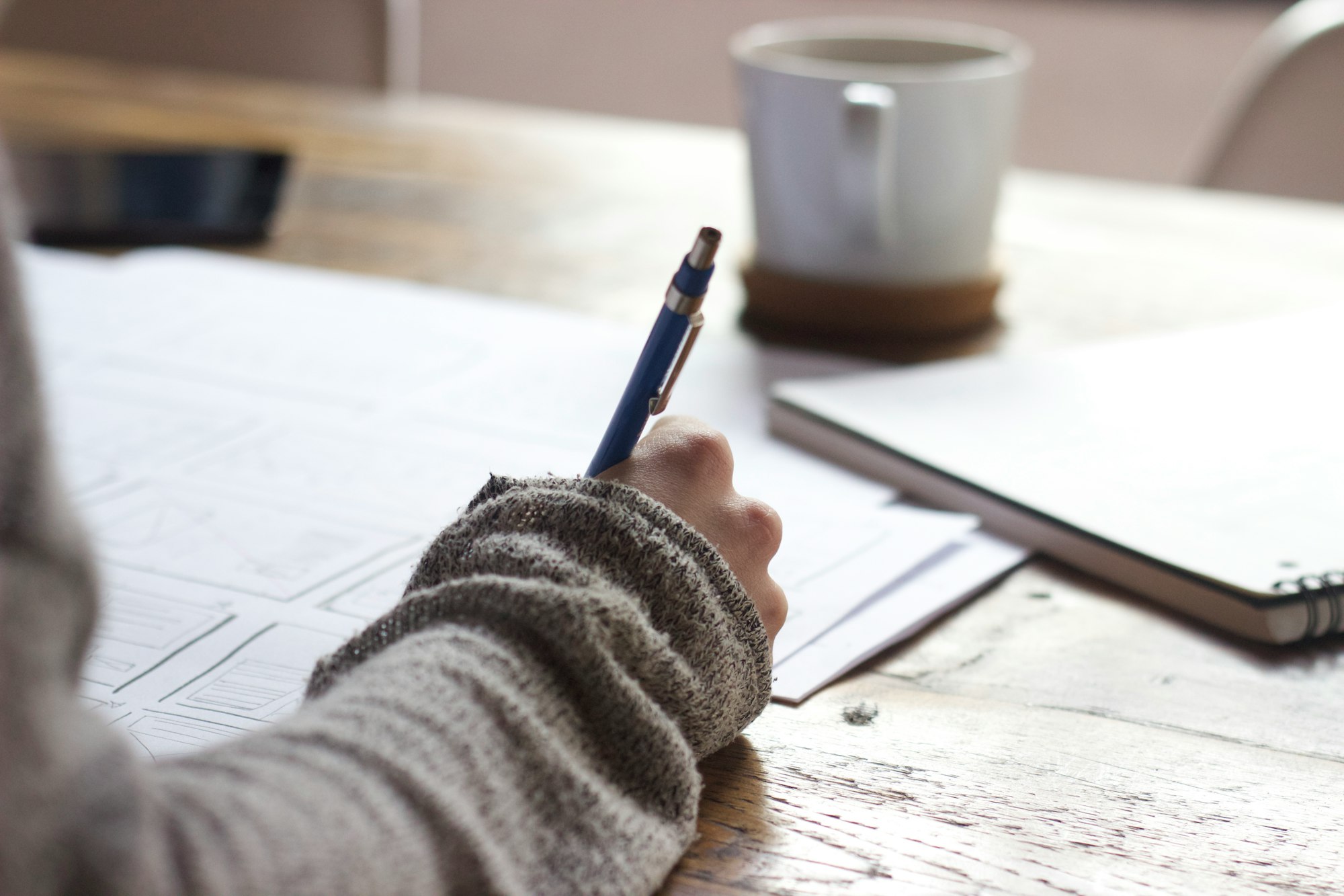 Boosting Traffic to Your Affiliate Website: Strategies, Tips, and Hacks 10 | Mania Africa | maniainc.com A person writing | What Role Does Content Quality Play in SEO? | Affiliate Marketing Guide | Mania Developers