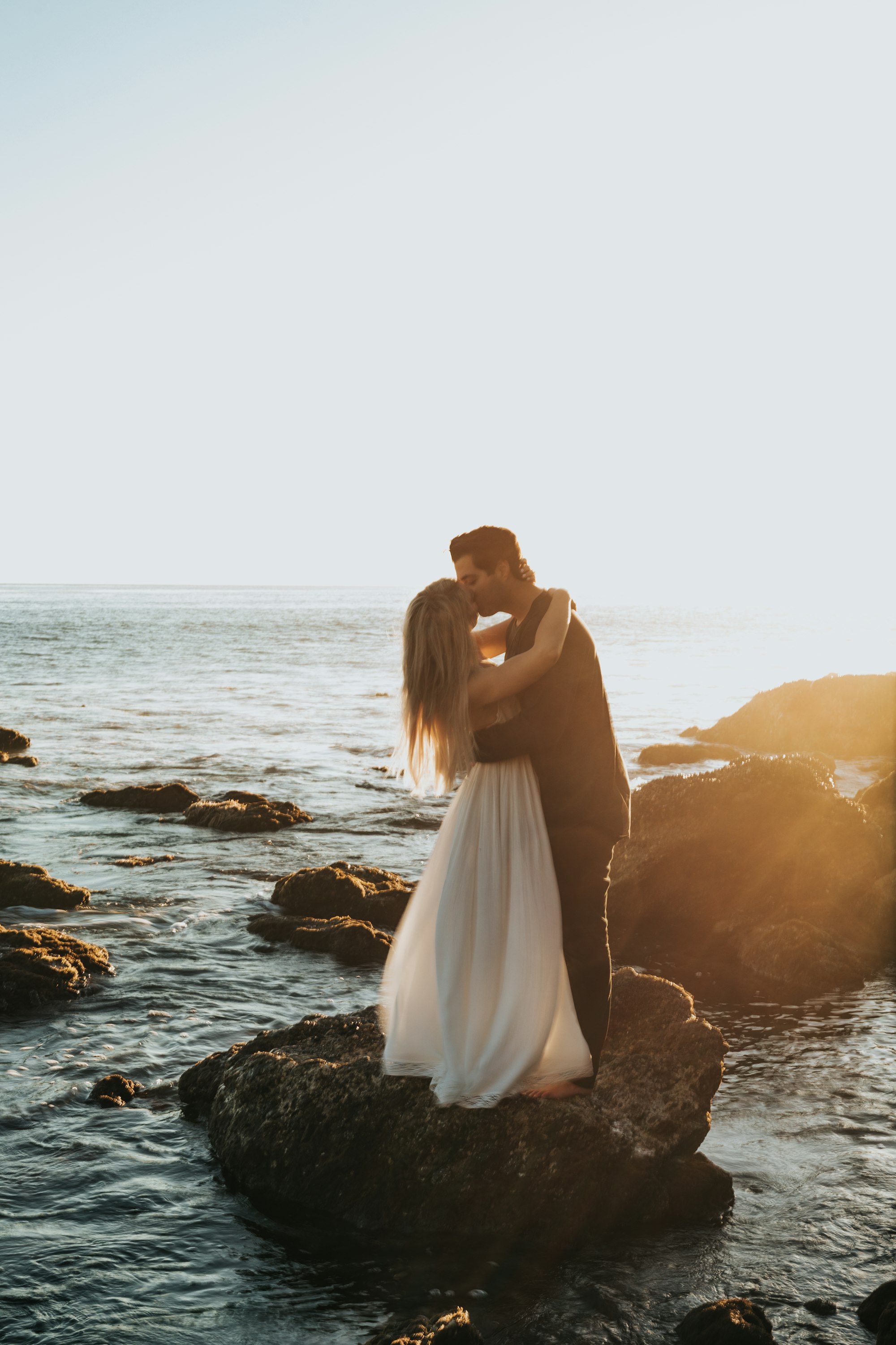 Why Doesnβt Anybody Talk About How Hard Love Is? 2 | Mania Africa | maniainc.com man and woman kissing on top of gray rock at beach | Real love can be very hard and isn