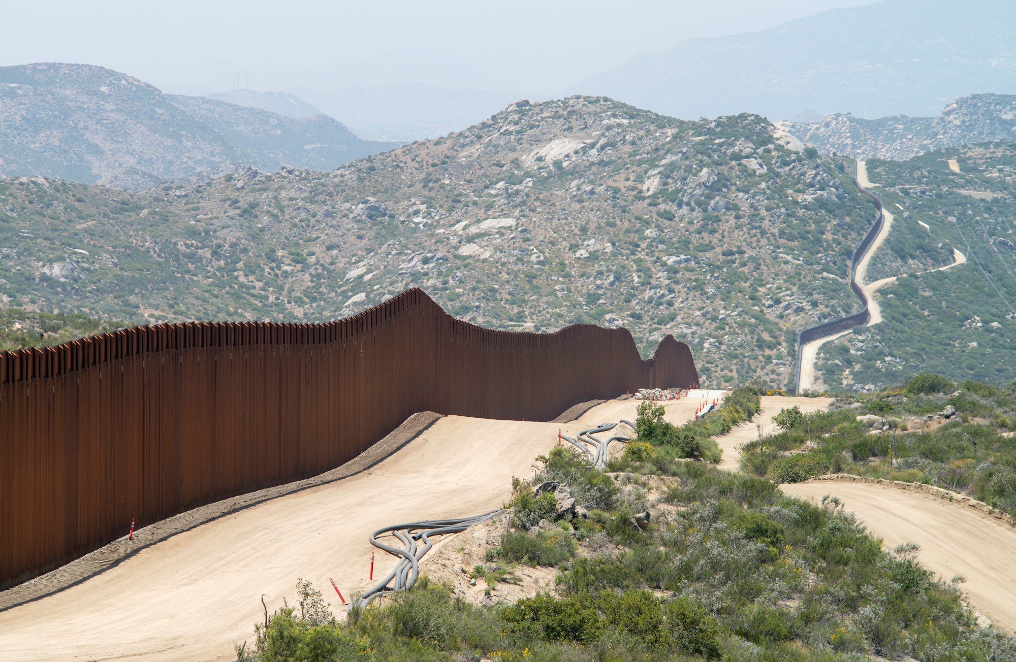 Conspiracy Theories and Extremism: Is a Civil War Looming in America? 18 | Mania Africa | maniainc.com The Trump wall on the border with Mexico | The Notion of