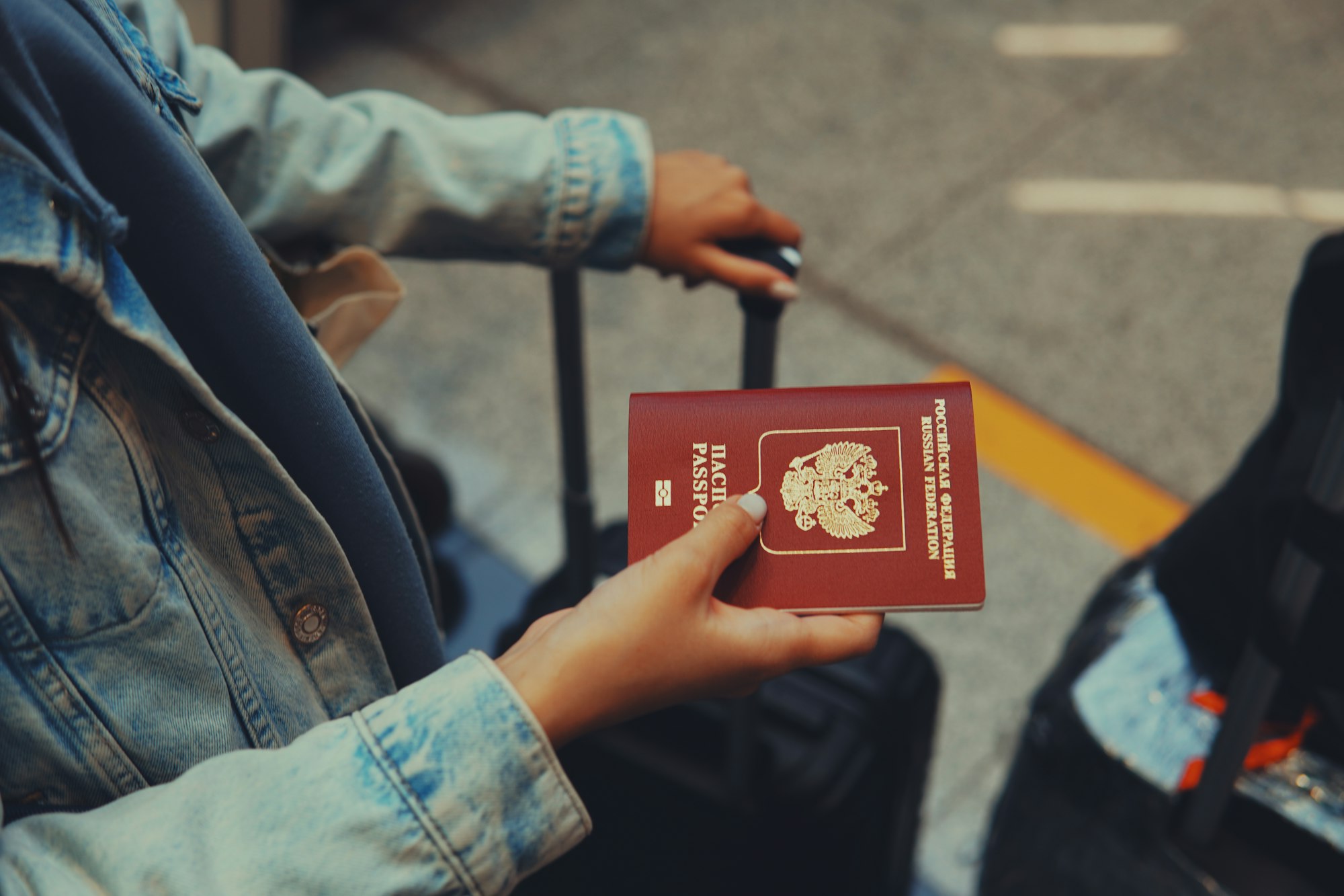 A woman holding a Russian passport | Defunding the War on Ukraine: Is Sanctioning Russian Oligarch