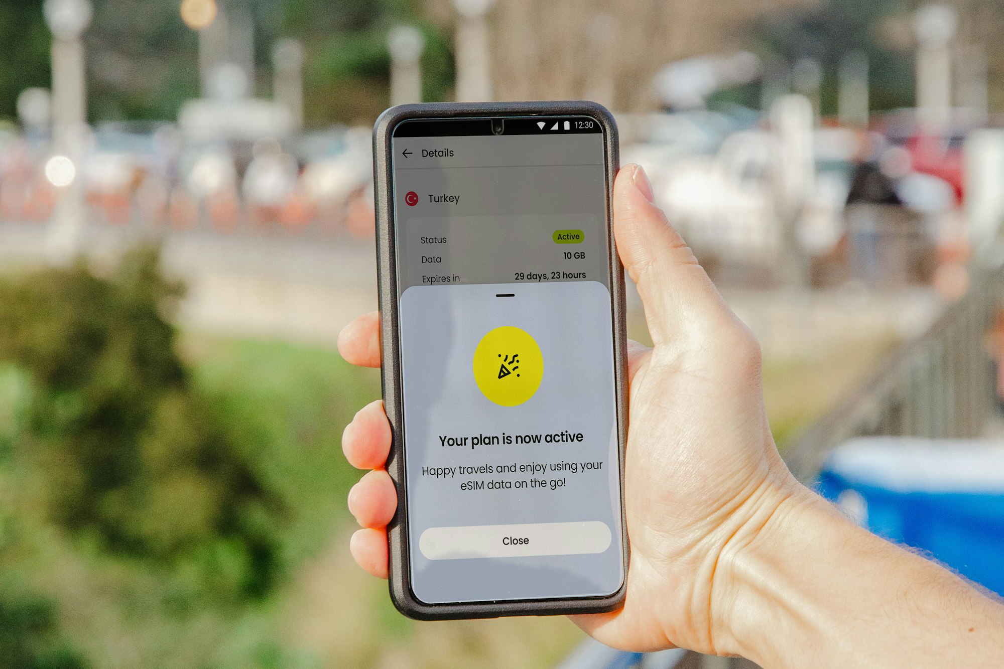 a person holding a cell phone in their hand while connecting to an eSIM | How to Choose & Start Using an eSIM | Mania Africa