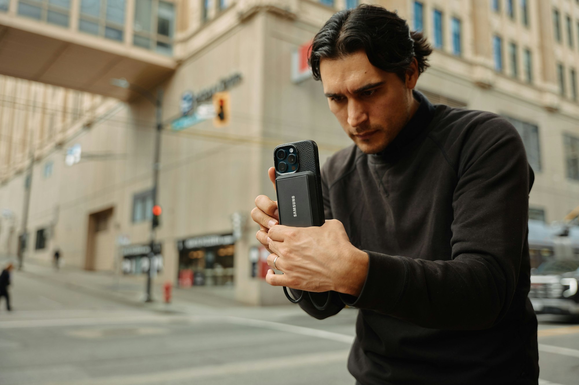 A man standing on the street looking at his cell phone | eSIM vs. Regular SIM Card: A Comparative Analysis | Mania Tech