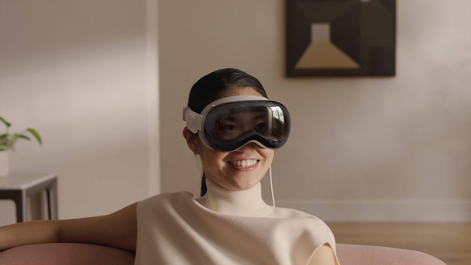 A user using Apple Vision Pro. The cord falling from beside the headset is for the battery which a user will place in their pocket.